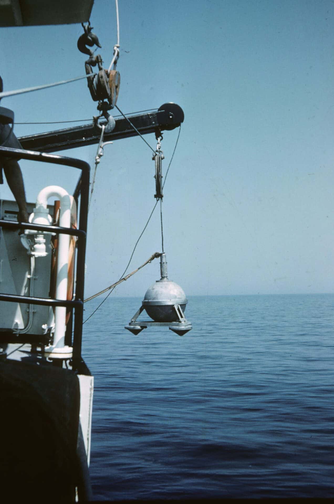 A marine research vessel is lowing monitoring equipment into the ocean above the reef